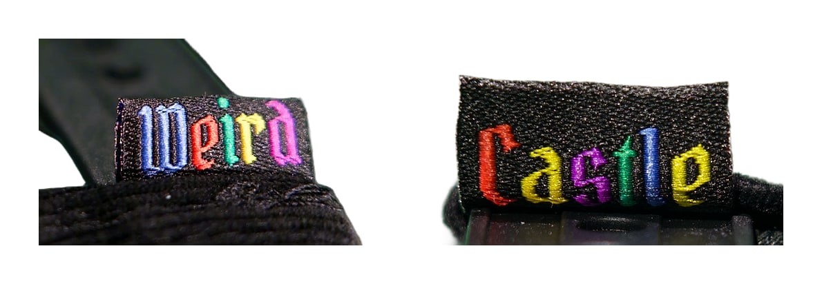 Macro: the woven snap tag — 'Weird' on one side, 'Castle' on the other, blackletter in full rainbow