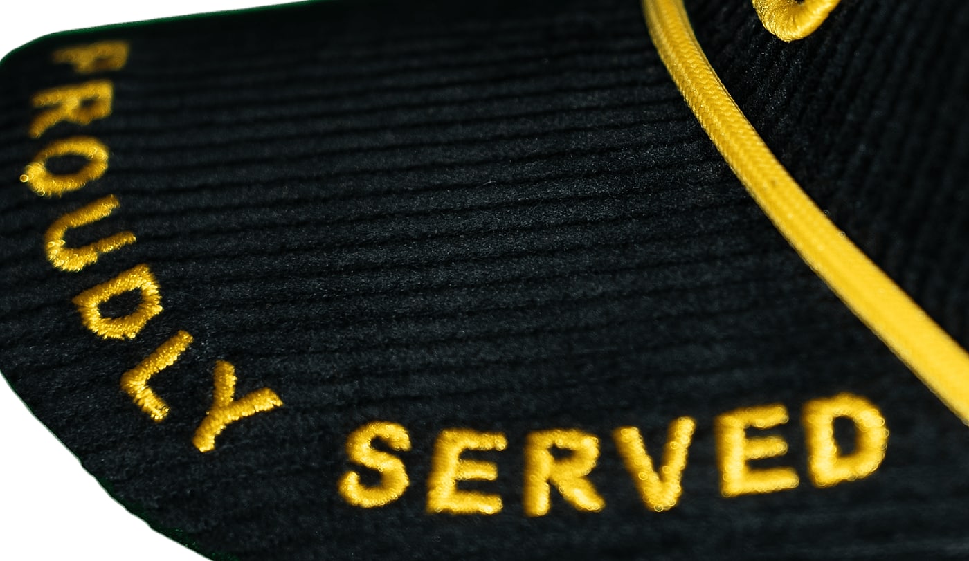 PROUDLY SERVED embroidered in gold along the corduroy brim